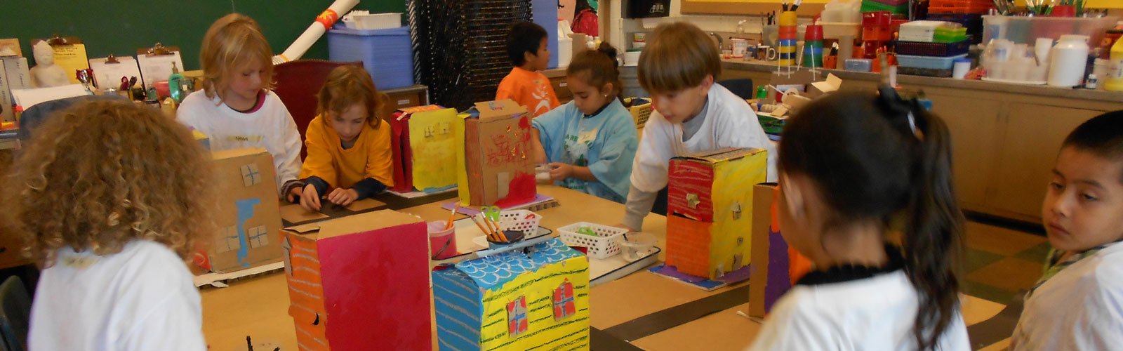 Shows elementary children making art.