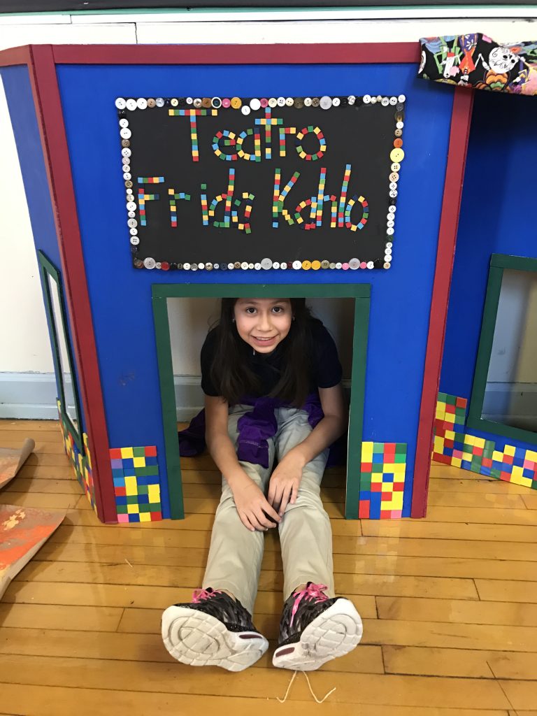Child sitting in a handmade shelter